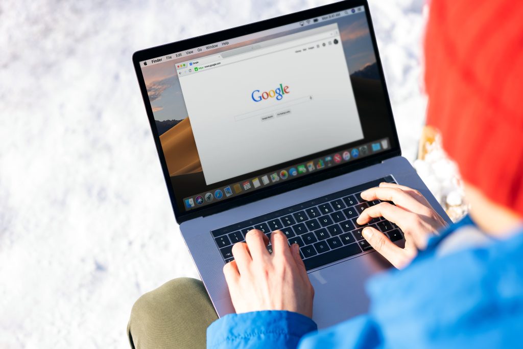 person searching google on macbook