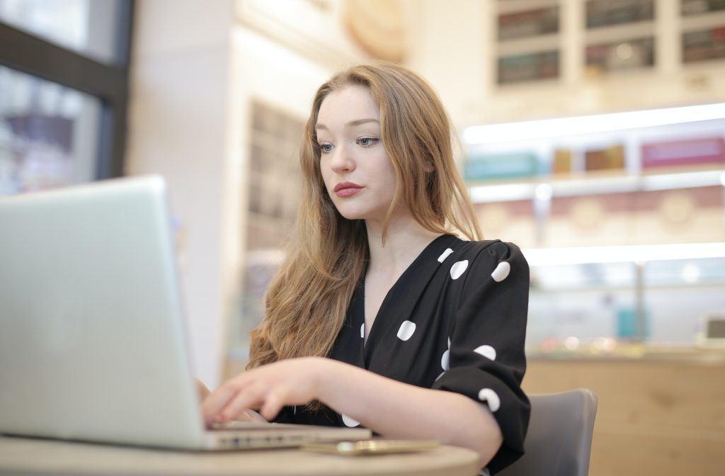 woman in black and white shirt using laptop