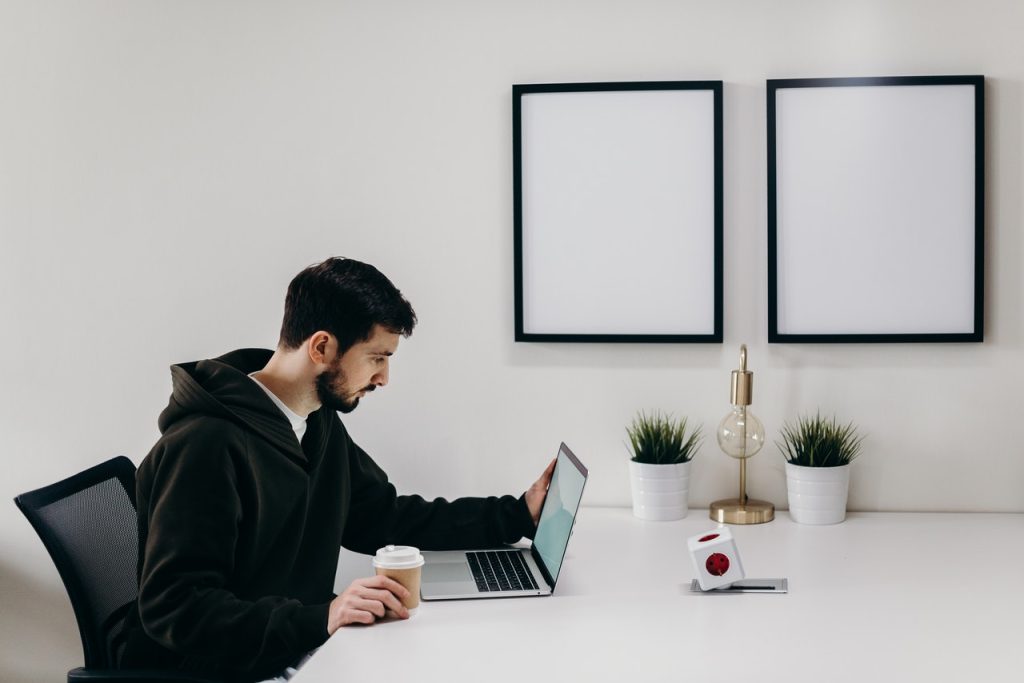 Man in black hoodie using laptop