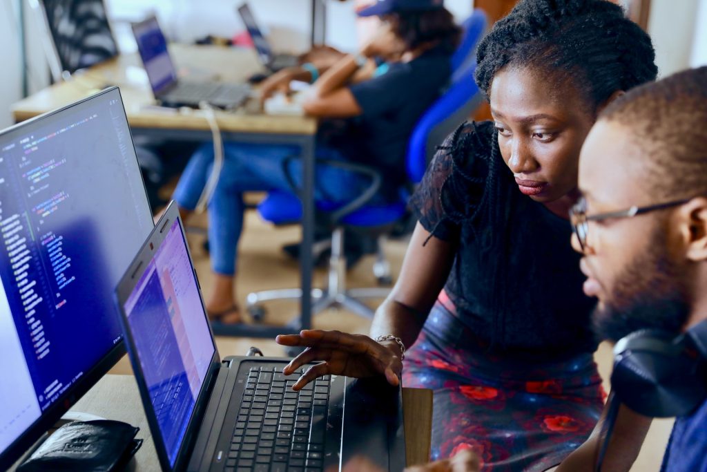 woman helping a man on laptop