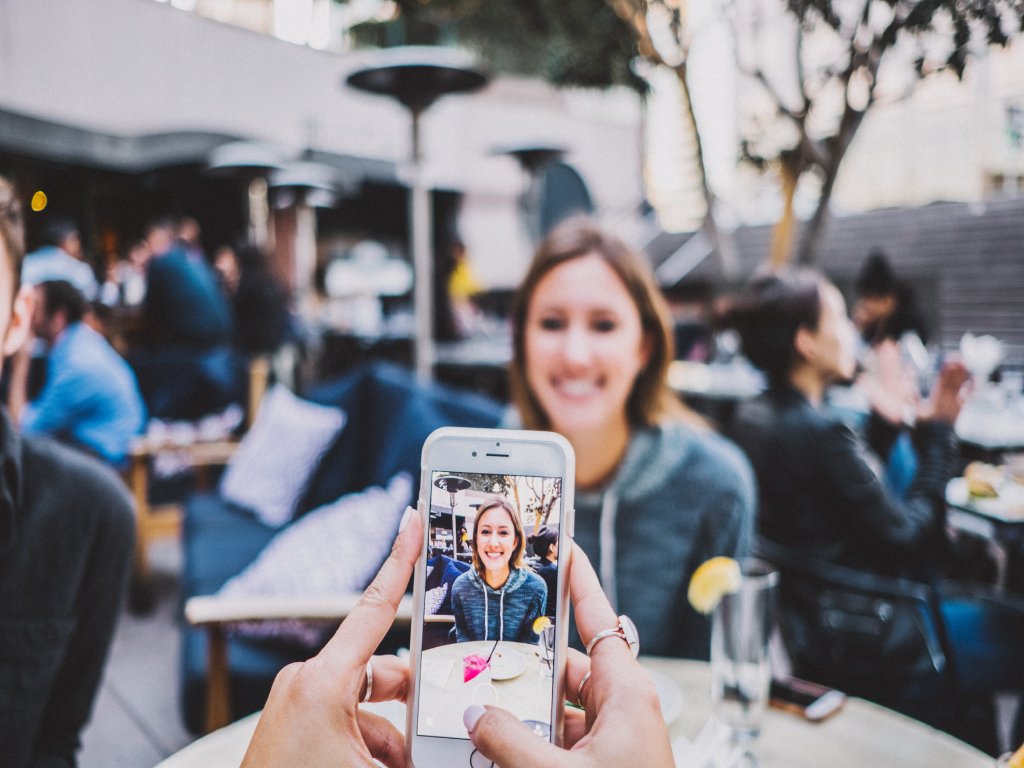 The girl creates a photo on her smartphone